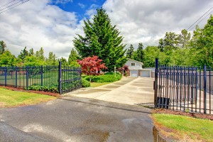 House exterior with open iron gate driveway and garage